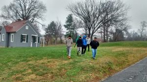 A portion of our student group is staying warm as they walk through the chilly 39 degree rain past the 1930s Sears model  house.