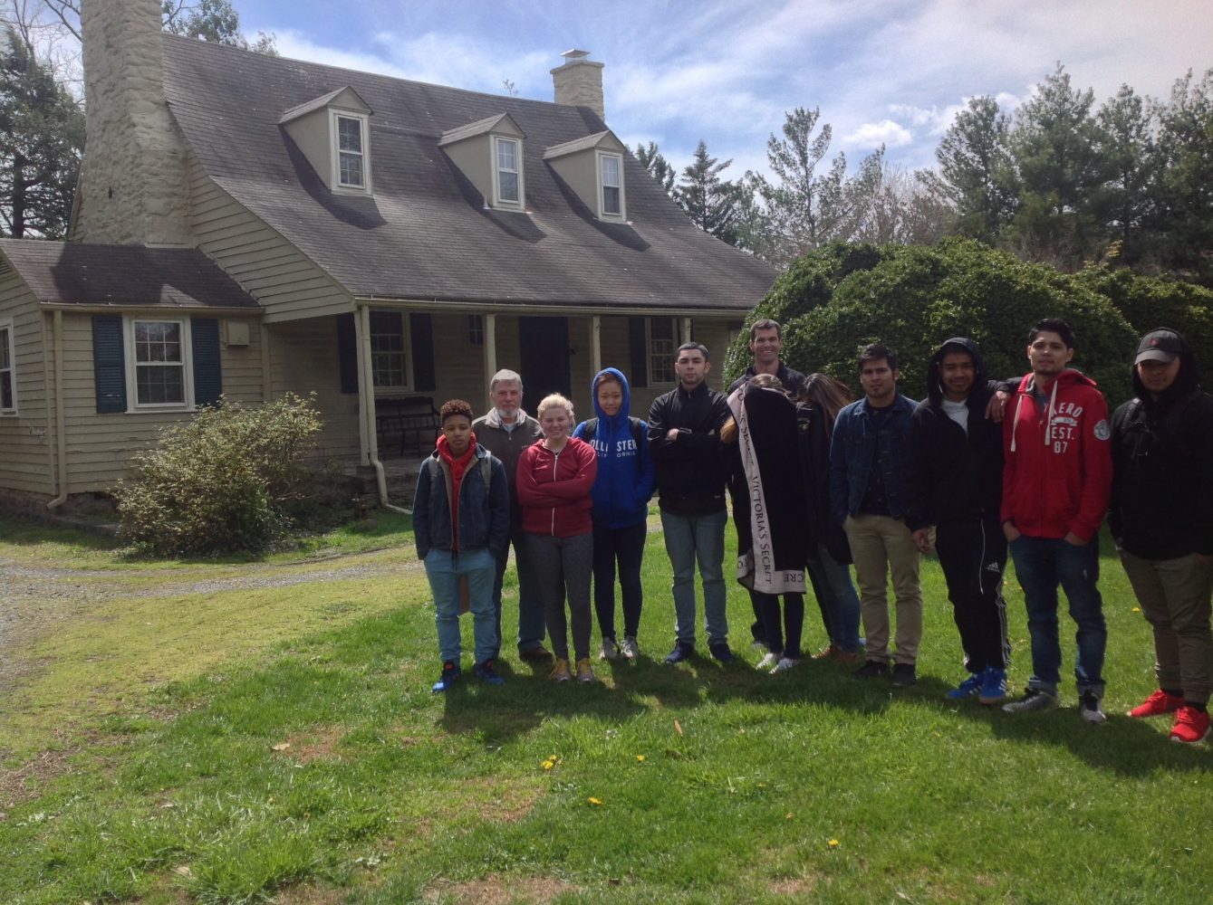 A group of students stands with the Professor in front of his historic home in the Mt. Gilead section of the historic district of Centreville, VA 