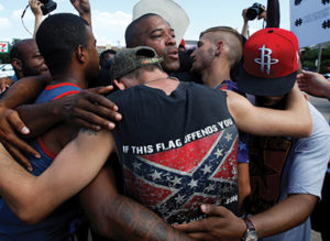 African-American and white men embrace after taking part in a prayer circle July 10 following a Black Lives Matter protest in Dallas. Theologians and justice advocates have called upon the church to better address racism as a life issue and see it as an intrinsic evil. (CNS photo/Carlo Allegri, Reuters) See WASHINGTON-LETTER-RACISM July 15, 2016.