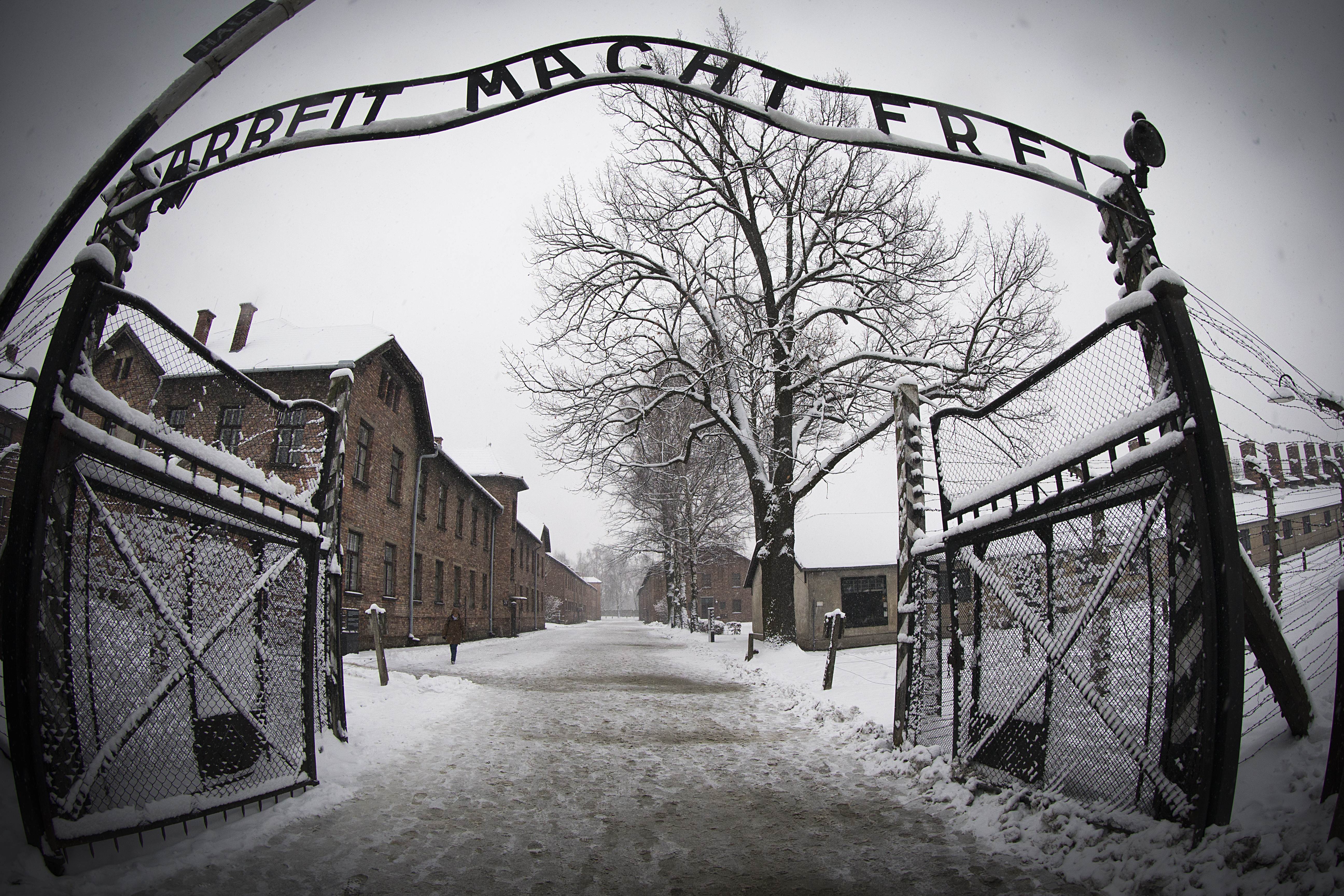 TOPSHOTS
A woman walks through snow near the entrance to the former Nazi concentration camp Auschwitz-Birkenau with the lettering 'Arbeit macht frei' ('Work makes you free') in Oswiecim, Poland on January 25, 2015, days before the 70th anniversary of the liberation of the camp by Russian forces. AFP PHOTO / JOEL SAGET