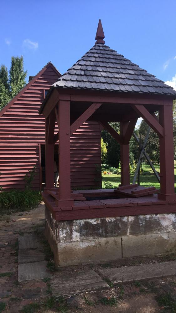 A fairytales water well at the Gunston Hall surrounded by an outdoors and indoors lundry, a kitchen, and also a dairy room.