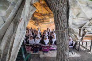 Girls study in a tent held up by a tree in a government school in Kabul, Afghanistan. Forty-one percent of all schools in Afghanistan do not have buildings and even when they do, they are often overcrowded, with some children forced to study outside. © 2017 Paula Bronstein for Human Rights Watch
