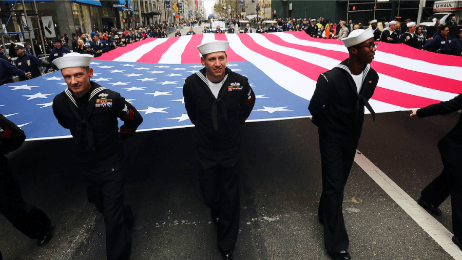 Members of the U.S. Navy march with the American flag in the nations largest Veterans Day Parade in New York City, November 11, 2015. Known as Americas Parade, it features more than 20,000 participants, including veterans of military units, high school bands and civic and youth groups. 