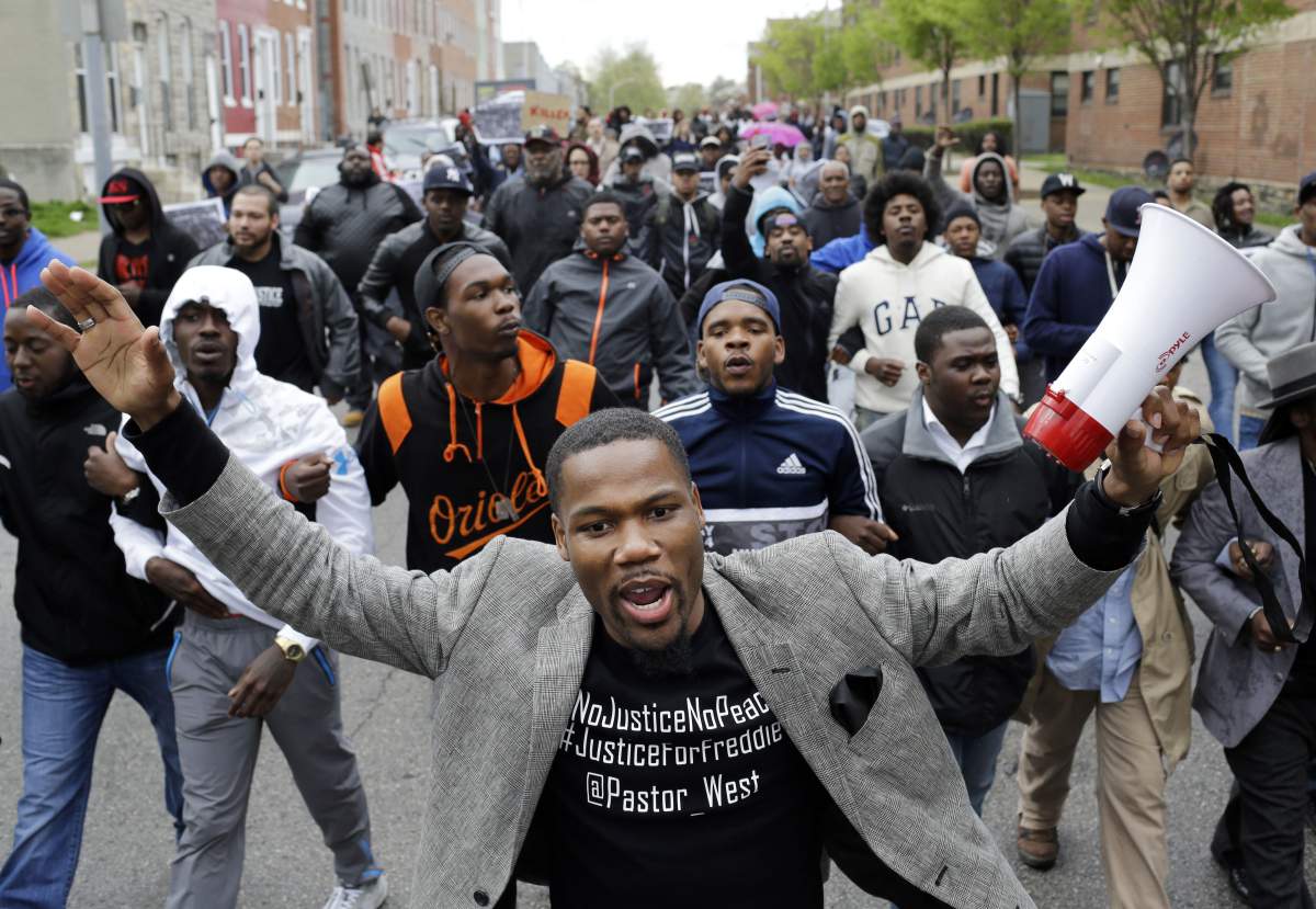 The+Rev.+Westley+West+leads+a+march+for+Freddie+Gray+to+the+Baltimore+Police+Departments+Western+District+police+station%2C+Wednesday%2C+April+22%2C+2015%2C+in+Baltimore.+Gray+died+from+spinal+injuries+about+a+week+after+he+was+arrested+and+transported+in+a+police+van.+%28AP+Photo%2FPatrick+Semansky%29